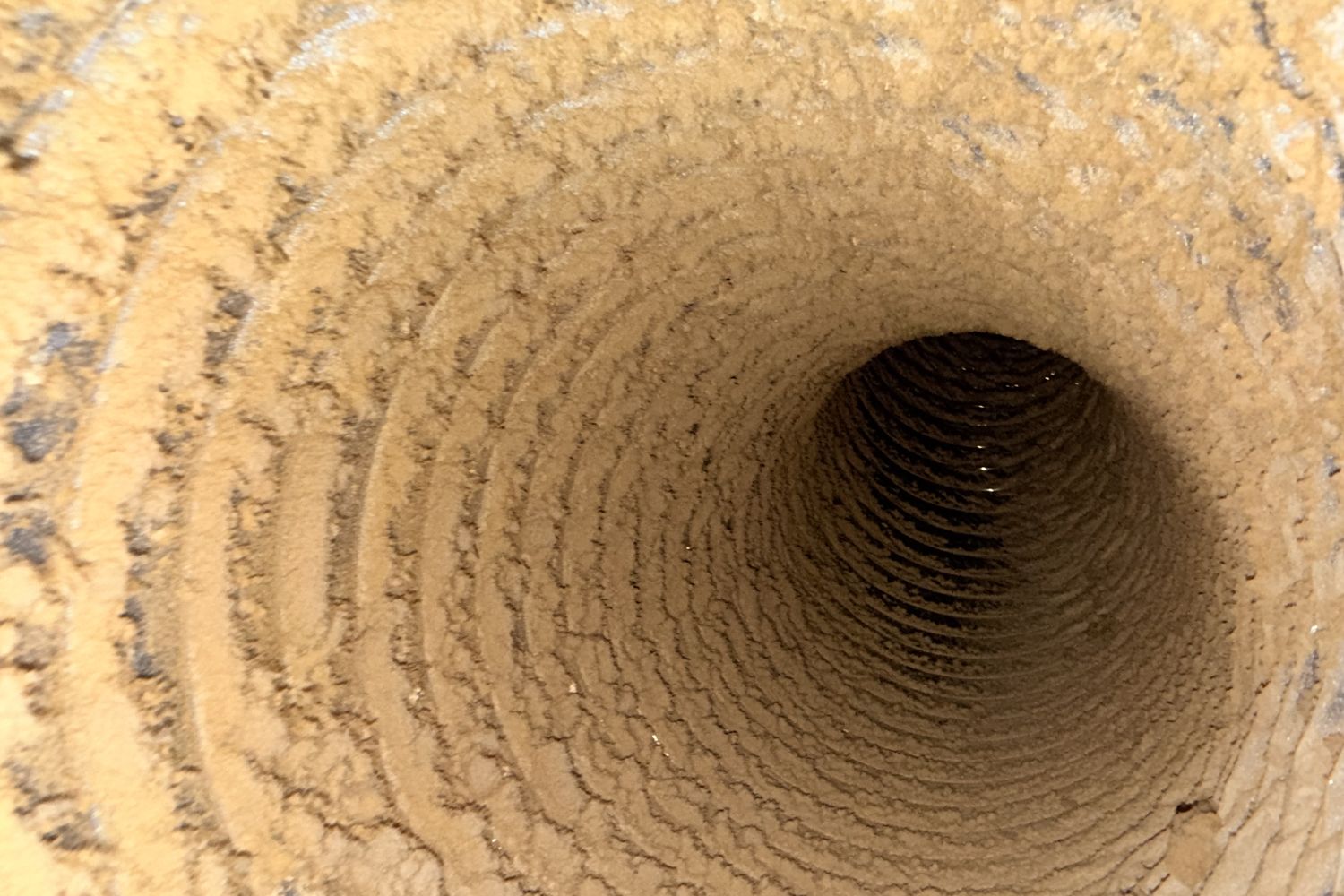 Dust and debris built up inside a supply duct before cleaning